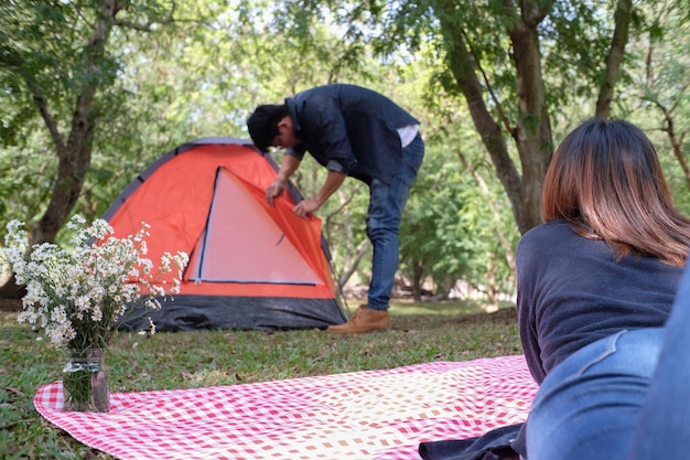 Paartourist baut Zelt auf dem Campingplatz im Wald auf