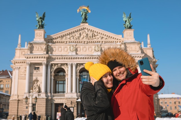 Paartouristen, die selfie vor dem operngebäude der lviv-stadt ukraine machen