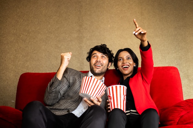 Paaruhrfilm im Theater mit Popcornlächeln und glücklichem Gesicht