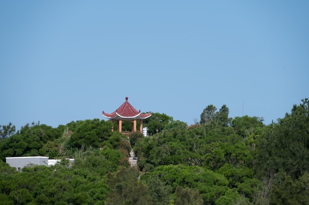 Foto el pabellón rojo entre los árboles verdes está bajo el cielo azul