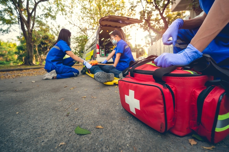 Foto paciente de accidente de emergencia sufrió en la cabeza acostada en camilla. entrenamiento de primeros auxilios y movimiento del paciente en caso de accidente de emergencia. el paramédico transfiere al paciente al coche de la ambulancia. seleccione centrarse en la bolsa de primeros auxilios.