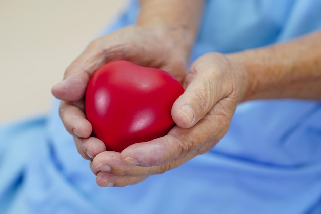 Paciente anciana asiática con corazón rojo en el hospital