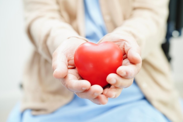 Paciente anciana asiática con corazón rojo en el hospital