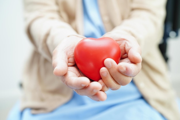 Paciente anciana asiática con corazón rojo en el hospital