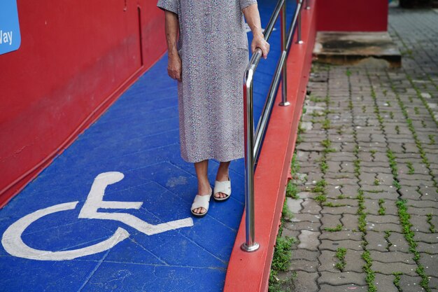 Paciente anciana asiática con símbolo de persona con discapacidad