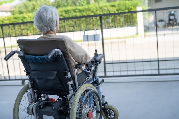 Paciente anciana o anciana asiática en silla de ruedas eléctrica con control remoto en la sala del hospital de enfermería concepto médico fuerte y saludable