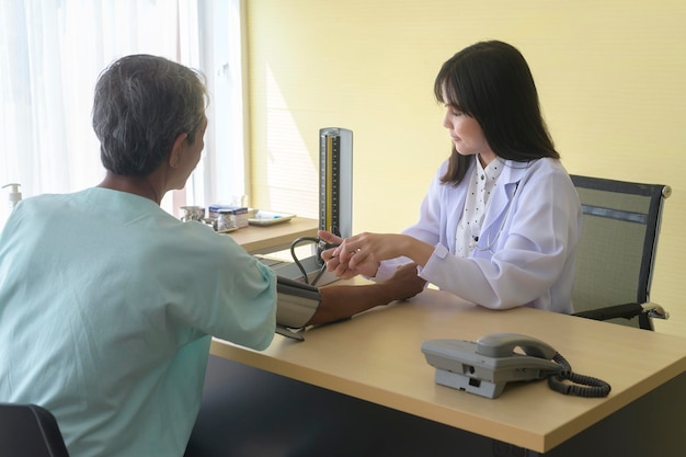 Un paciente asiático mayor está consultando y visitando a un médico en el hospitalx9xA