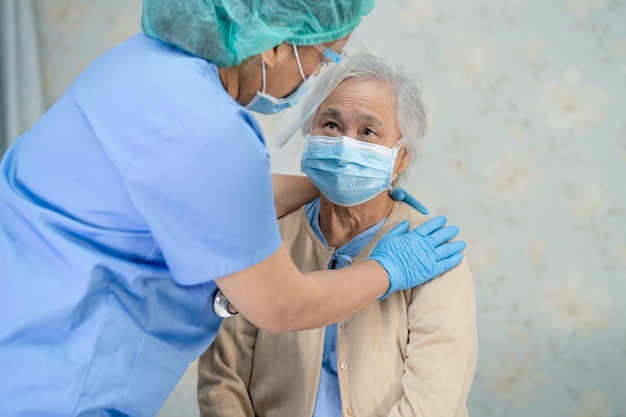 Paciente asiático mayor o anciana con una mascarilla nueva normal en el hospital para proteger la infección de seguridad Covid-19 Coronavirus.