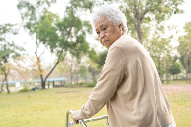 Paciente asiático mayor o anciano mujer caminar con andador en el parque con espacio de copia, concepto médico fuerte y saludable