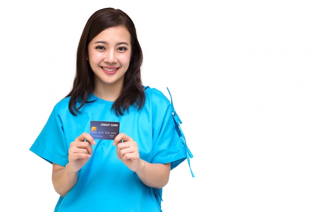 Paciente asiático novo da mulher bonita que mostra o cartão de crédito isolado, apólice de seguro pelo conceito do banco