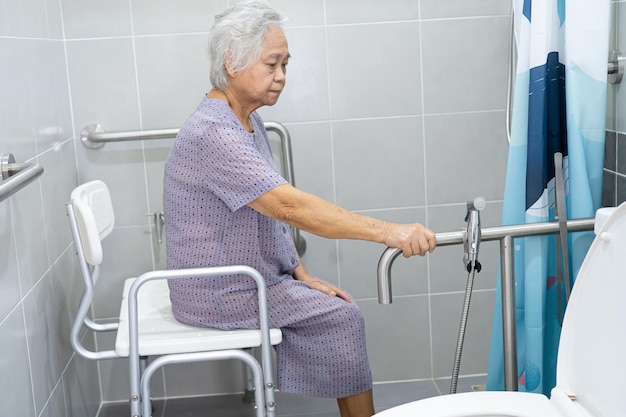 Paciente asiático sênior ou idosa senhora idosa usar banheiro banheiro lidar com segurança na enfermaria do hospital de enfermagem, conceito médico forte saudável.