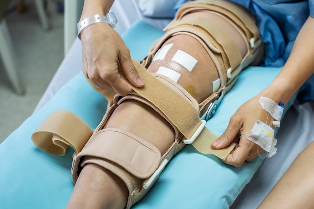 Paciente com lesão de suporte de cinta de compressão de bandagem na cama no hospital de enfermagem. assistência médica e médica.