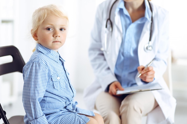 Paciente criança sorridente feliz na inspeção médica habitual. Médico e paciente na clínica. Medicina, conceitos de saúde.