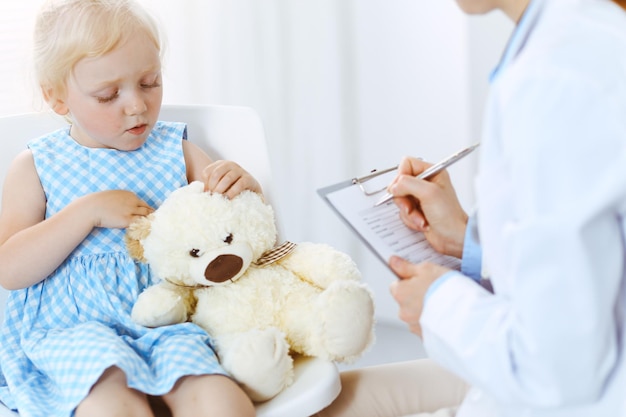 Paciente criança sorridente feliz na inspeção médica habitual. Médico e paciente na clínica. Medicina, conceitos de saúde.