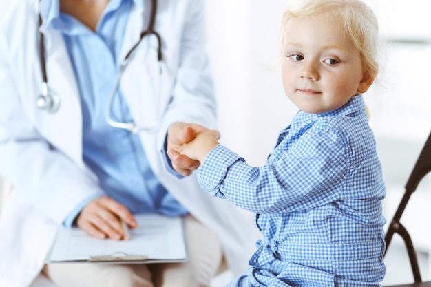 Paciente criança sorridente feliz na inspeção médica habitual. Médico e paciente na clínica. Medicina, conceitos de saúde.