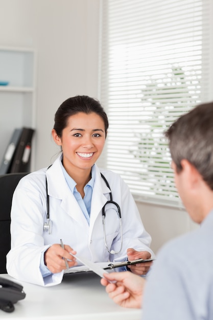 Paciente dando a su doctora una hoja de papel