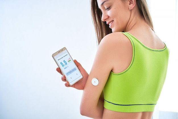 Paciente diabético, verificar o nível de glicose com um sensor remoto e smartphone.