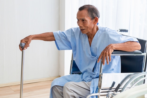 Foto paciente do homem sênior em sua cadeira de rodas no hospital.