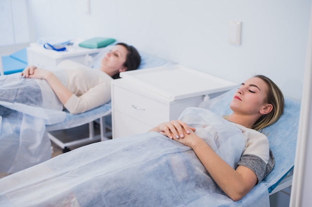 Paciente do sexo feminino dormindo na cama médica na enfermaria do hospital