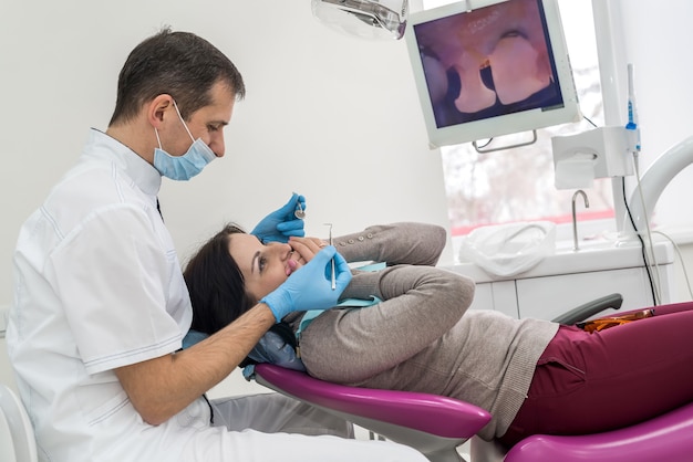 Paciente e dentista olhando para tela na odontologia