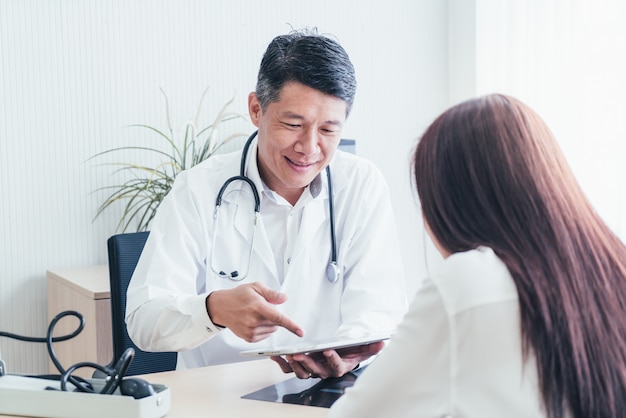 Paciente e médico asiático estão discutindo