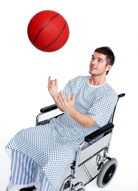 Paciente em cadeira de rodas se divertindo com uma bola de basquete