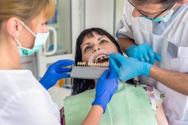 Paciente em odontologia comparando seus próprios dentes com amostrador