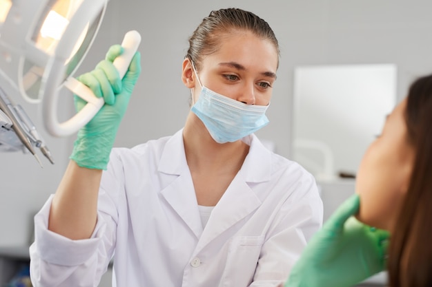 Paciente examinador mujer dentista