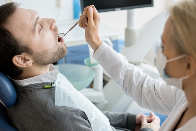 Paciente examinando dentista feminino