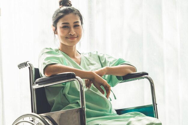 Paciente feliz sentado en silla de ruedas en el hospital. Concepto de salud médica.