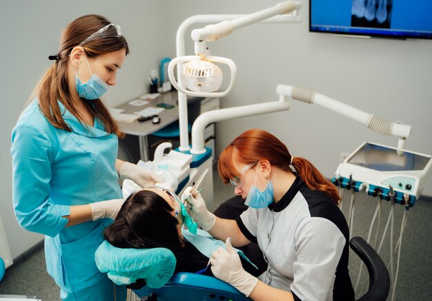 Paciente femenino está sentado en la silla del dentista en la clínica estomatológica.