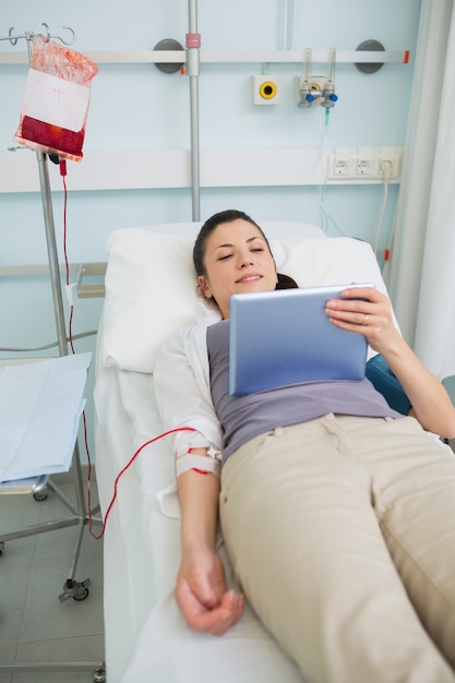 Paciente femenino transfundido sosteniendo una tableta