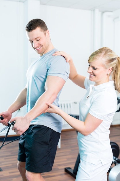 Paciente en fisioterapia haciendo ejercicios físicos con cable Bowden