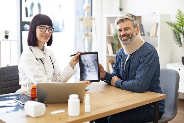 Paciente hablando con un médico con rayos x en la sala de consulta