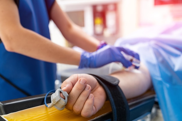 Paciente con herramienta especial en su dedo tendido en la sala de medicina Concepto de anestesia Enfermera que prepara al paciente para la operación Vista recortada