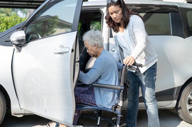 Paciente idosa asiática ou idosa sentada na cadeira de rodas se prepara para chegar ao seu carro conceito médico forte e saudável