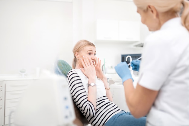 Foto paciente jovem de dentistas com medo de tratamento odontológico