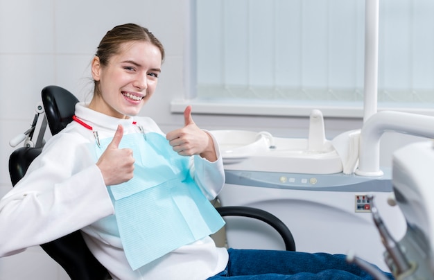 Foto paciente jovem feliz no dentista