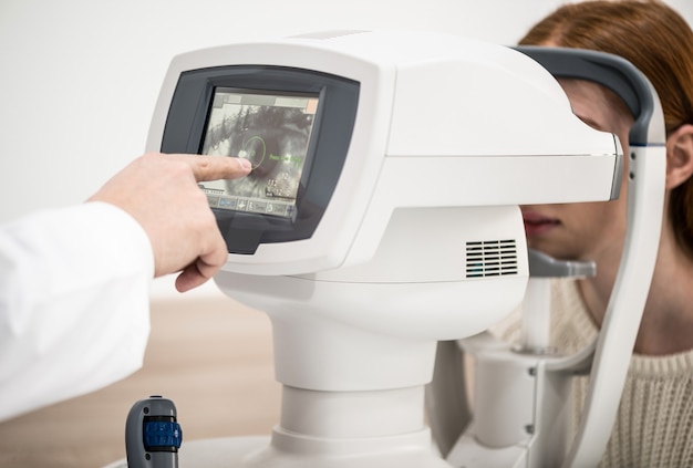 Paciente jovem na recepção do médico oftalmologista equipamento de diagnóstico oftalmológico