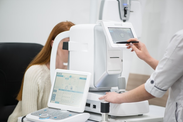 Paciente jovem na recepção no médico oftalmologista Equipamento oftalmológico de diagnóstico