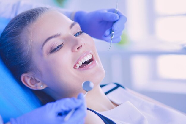 Paciente joven con la boca abierta examinando la inspección dental en el consultorio del dentista