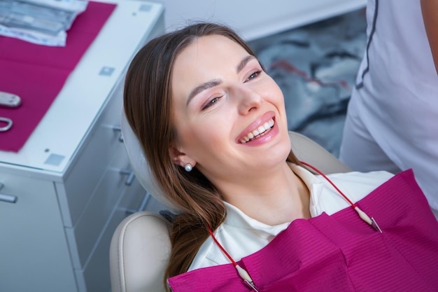 Foto paciente joven con una sonrisa bonita examinando la inspección dental en la clínica del dentista dientes sanas