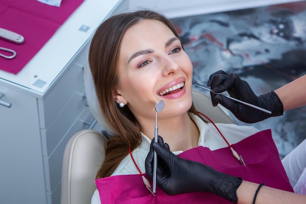 Foto paciente joven con una sonrisa bonita examinando la inspección dental en la clínica del dentista dientes sanas