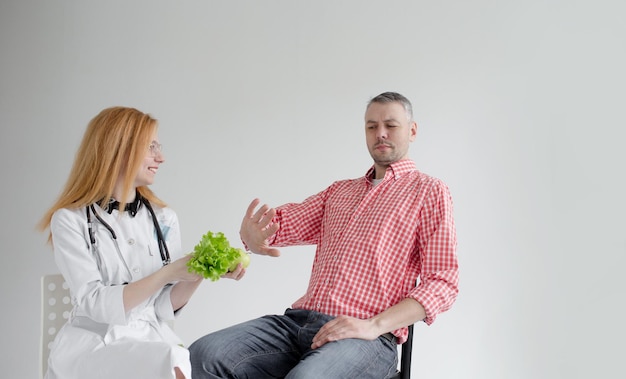 El paciente masculino rechaza la comida saludable ofrecida por un nutricionista Dietética de alimentos vegetales saludables