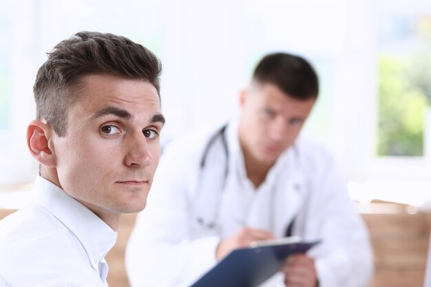 Paciente masculino sorridente bonito feliz satisfeito com o médico