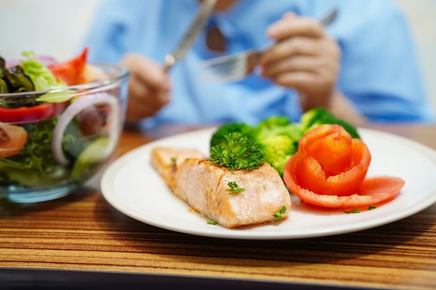 Paciente mayor asiático de la mujer de la señora mayor que come el alimento sano del desayuno en hospital.