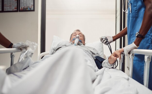 Foto paciente mayor del hospital y médicos de emergencia en una cama con máscara de oxígeno para atención médica anciano enfermo con problemas de salud y equipo médico o cirugía en el quirófano para obtener seguro de vida y ayuda