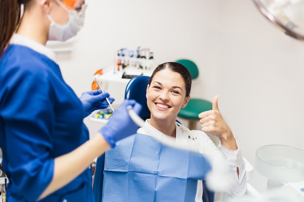 Paciente menina sorrindo na cadeira do dentista