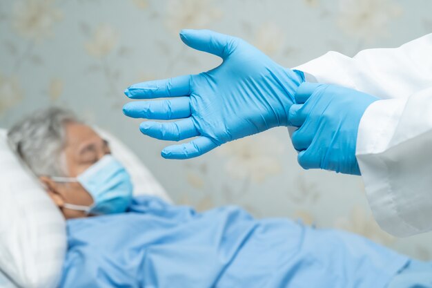 Foto paciente mujer asiática senior con una máscara facial con el médico en el hospital para proteger el virus covid-19.