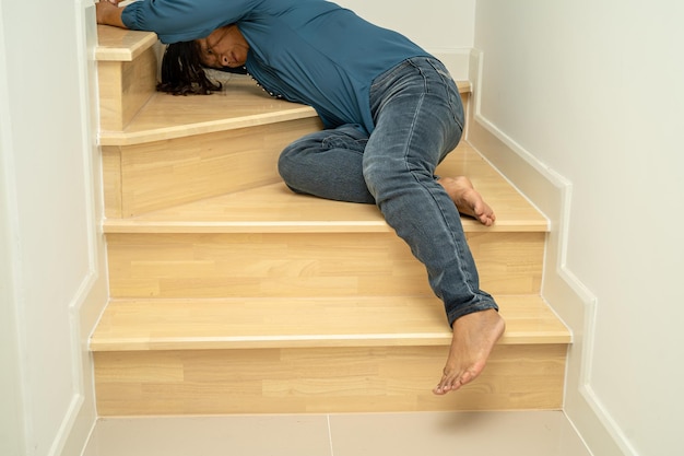 Paciente mujer dama asiática cae por las escaleras porque superficies resbaladizas